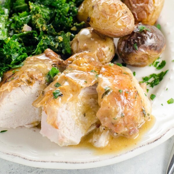 roast chicken and potatoes with kale salad on a plate