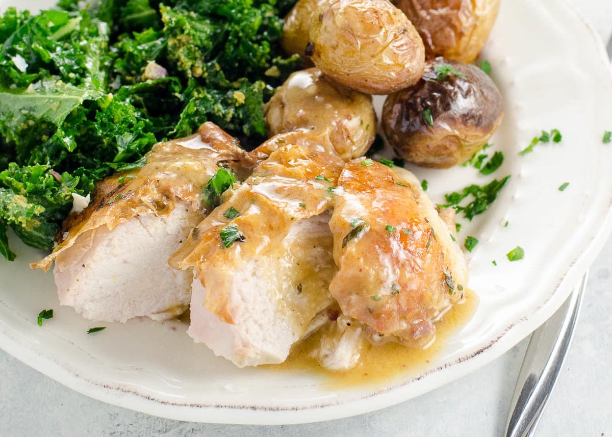 roast chicken and potatoes with kale salad on a plate
