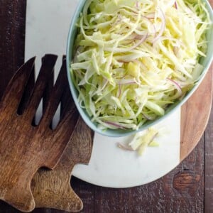 alice waters vegan coleslaw recipe with no mayo in a bowl with salad hands