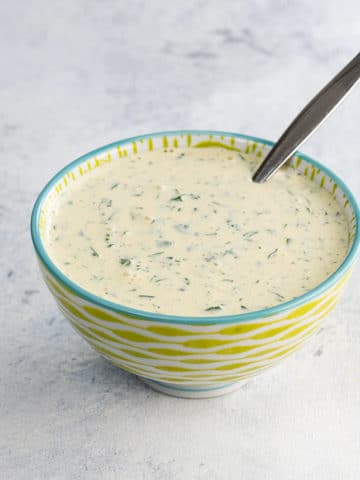 cilantro mayo in a bowl with a spoon