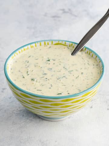 cilantro mayo in a bowl with a spoon
