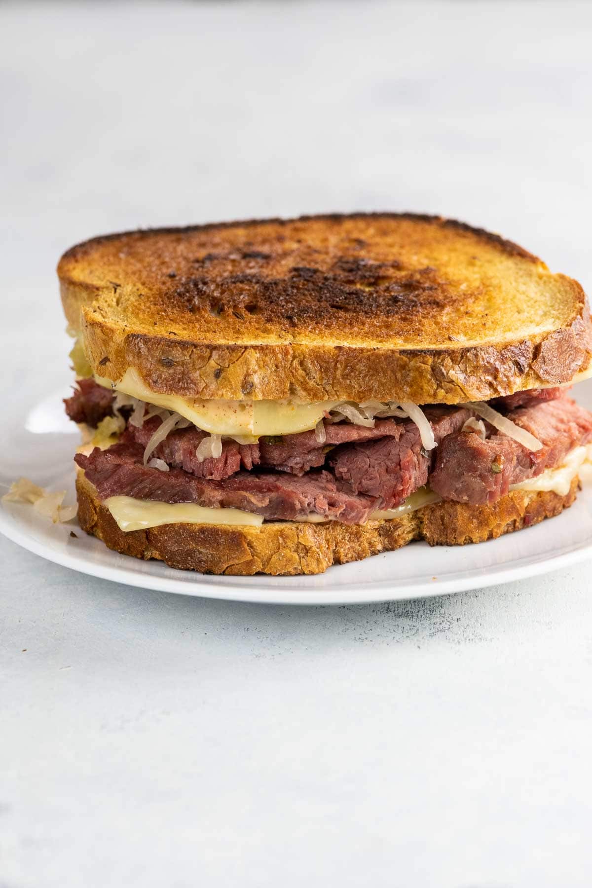 corned beef on rye (Reuben sandwich) on a white plate