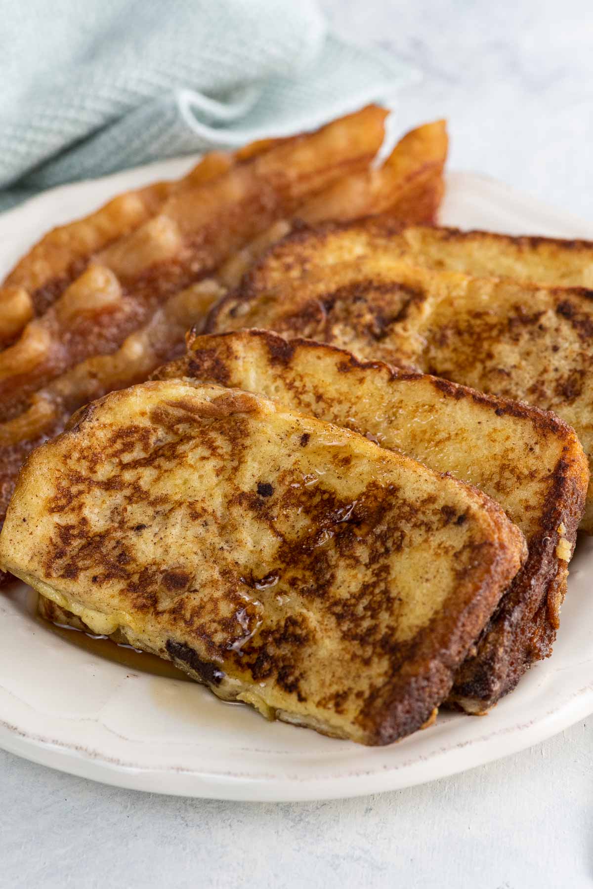 everyday french toast and bacon on a plate with a fork and napkin