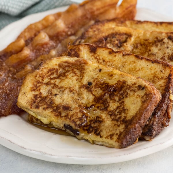 everyday french toast and bacon on a plate with a fork and napkin