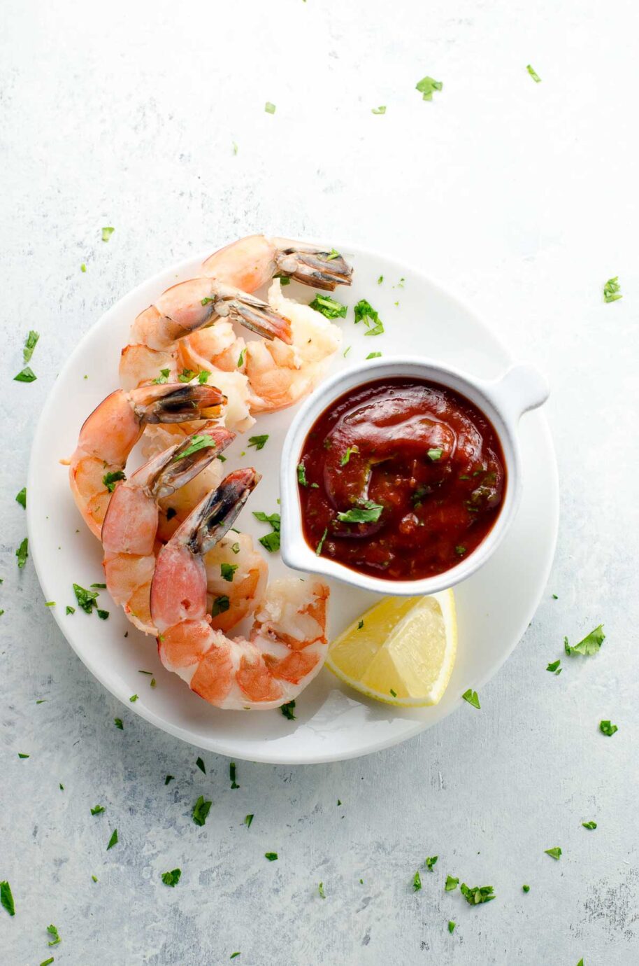 best shrimp cocktail recipe with cocktail sauce and a lemon wedge on a plate