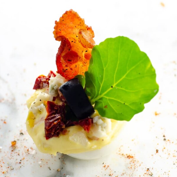 a cobb salad deviled egg on a marble background