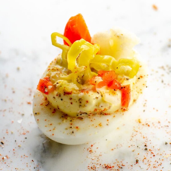 a giardiniera deviled egg on a marble background