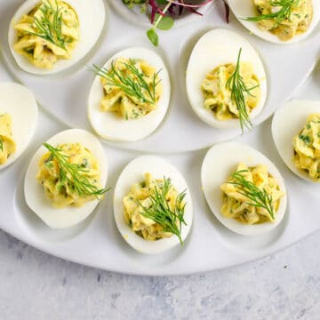 herbed deviled eggs garnished with dill on a platter