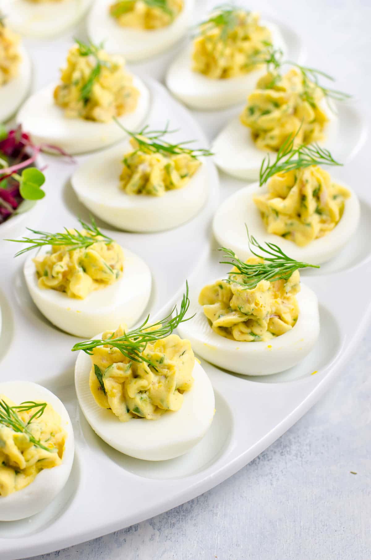 herbed deviled eggs garnished with dill on a platter
