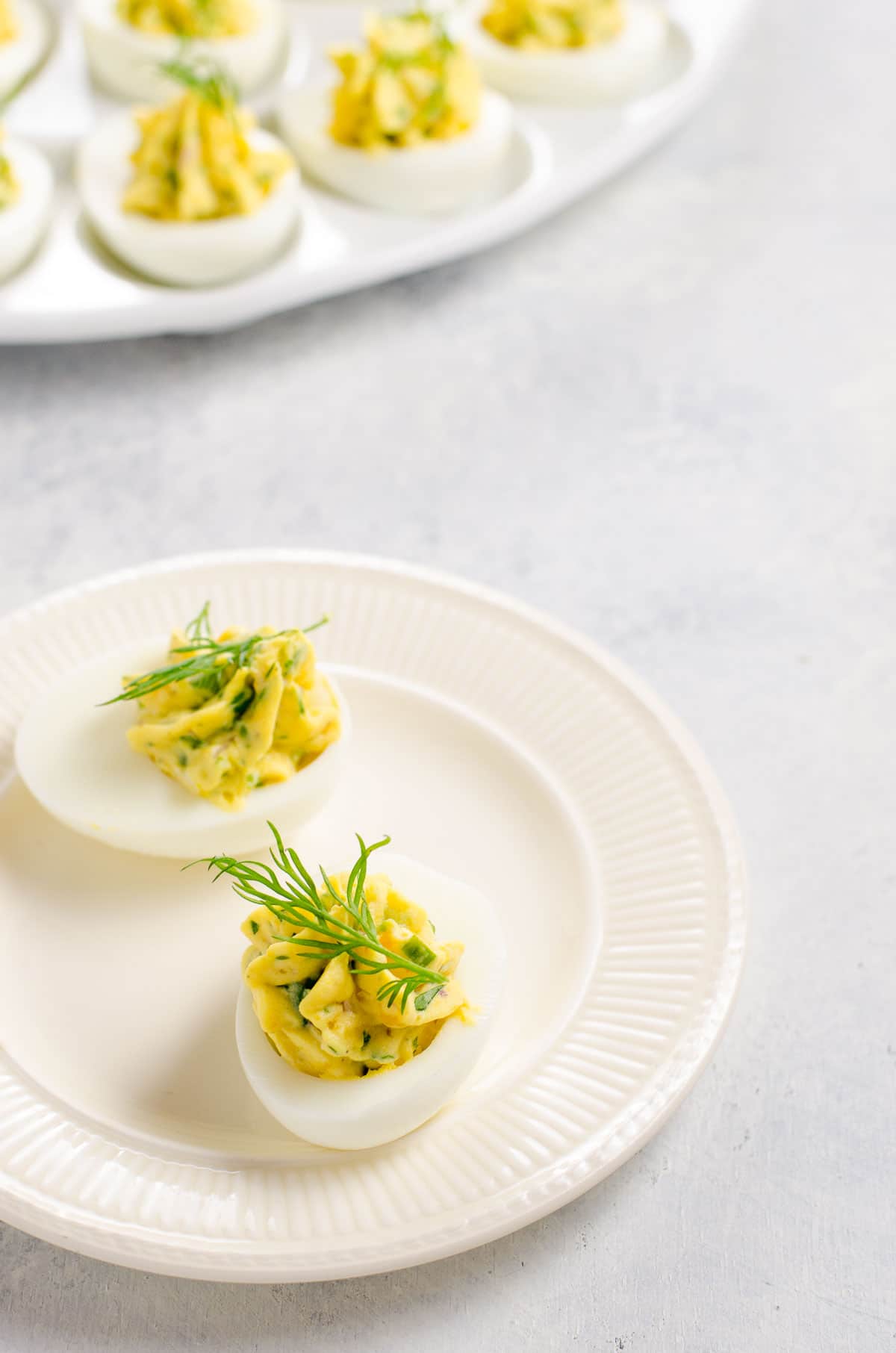 herbed deviled eggs garnished with dill on a plate