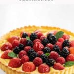 lemon curd tart with shortbread crust and berries on a cake stand