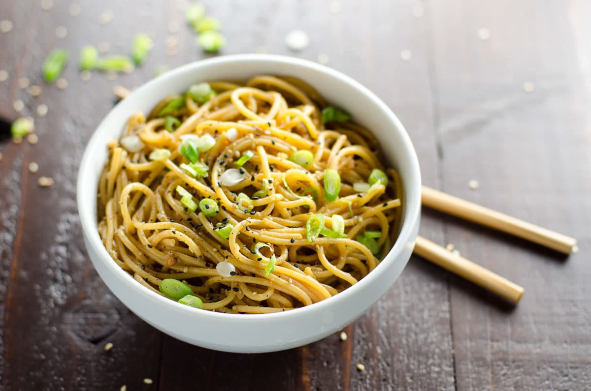 spicy sesame garlic noodles in a bowl with chopsticks