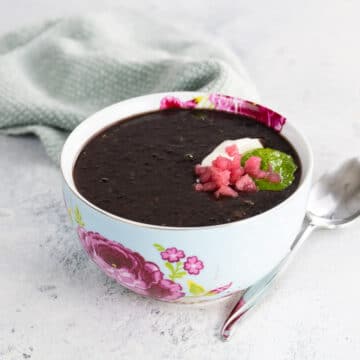 vegan black bean soup in a bowl with a spoon and napkin