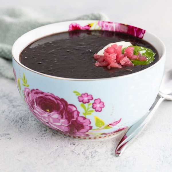 vegan black bean soup in a bowl with a spoon and napkin