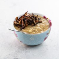 vegan savory oatmeal with shiitake bacon in a bow with a spoon