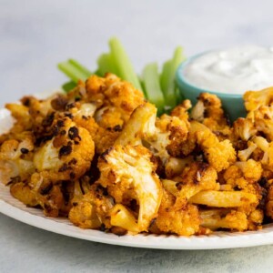 buffalo roasted cauliflower with celery and ranch dressing on a plate