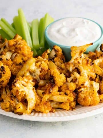 buffalo roasted cauliflower with celery and ranch dressing on a plate