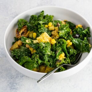 lemon garlic kale salad with halloumi in a bowl with a fork
