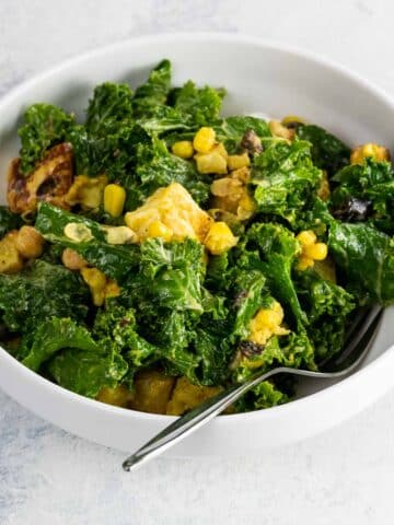 lemon garlic kale salad with halloumi in a bowl with a fork