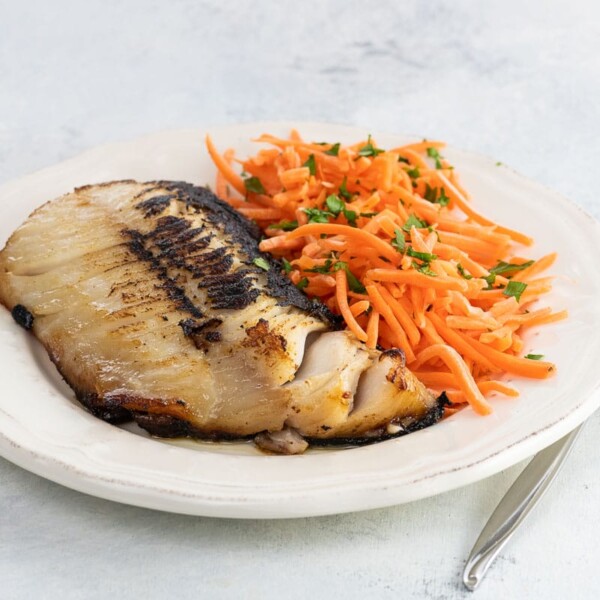 Nobu miso black cod on a plate with shredded carrots and parsley