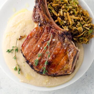 brown butter white bean puree underneath a pork chop with shredded brussels sprouts