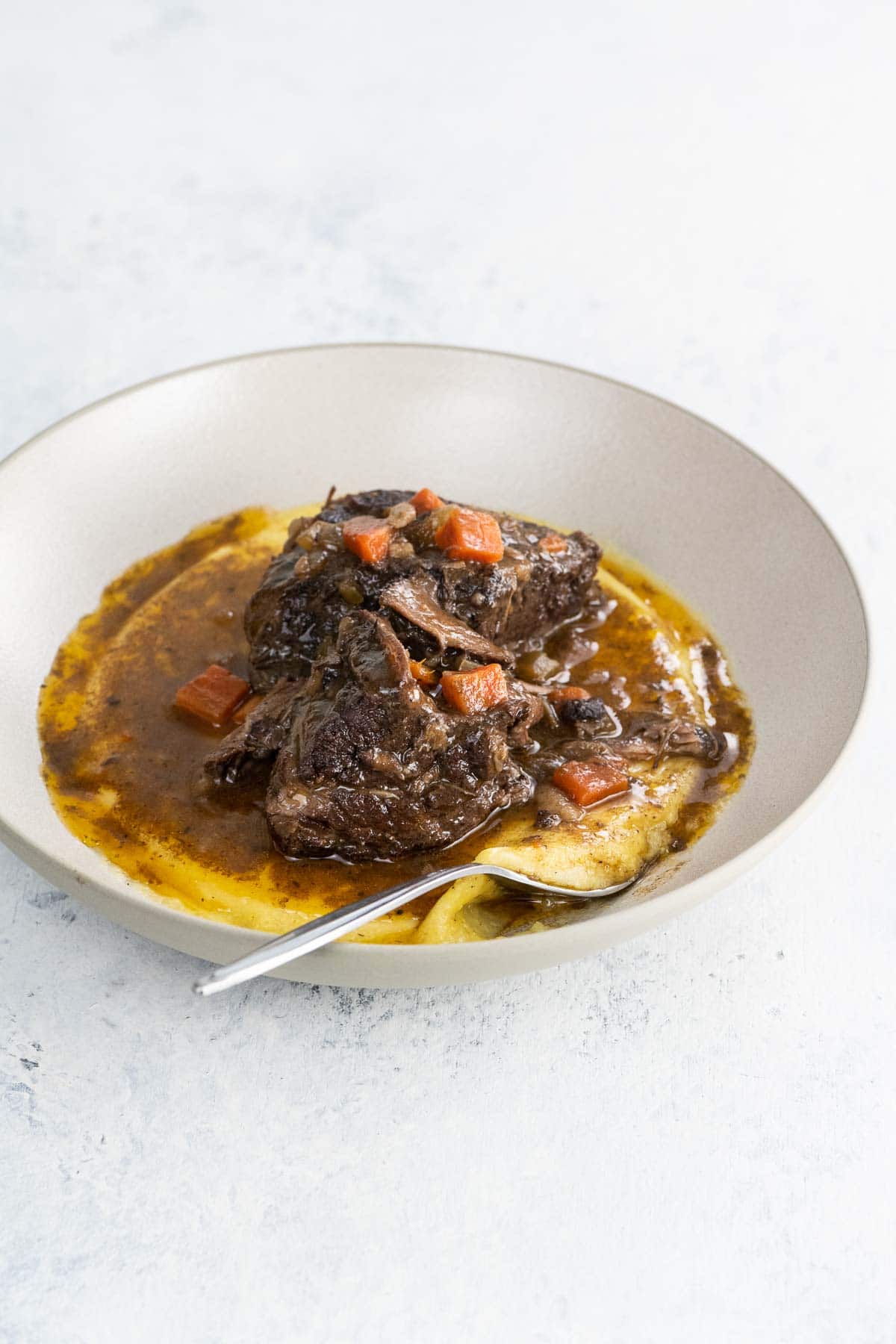 a bowl with braised beef short ribs and polenta