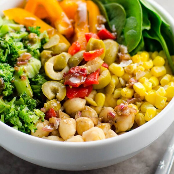 a veggie power bowl with chickpeas, broccoli, corn, spinach, peppers, olives, and balsamic vinaigrette