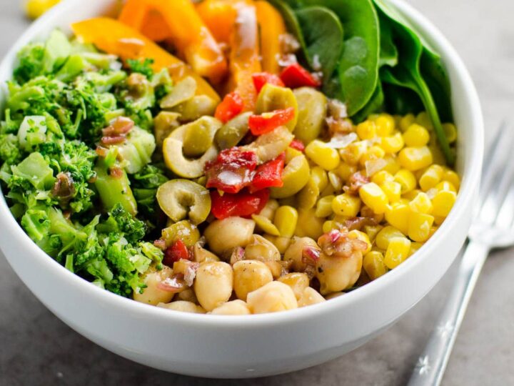 a veggie power bowl with chickpeas, broccoli, corn, spinach, peppers, olives, and balsamic vinaigrette