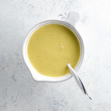 creamy lemon vinaigrette in a small white pitcher with a spoon