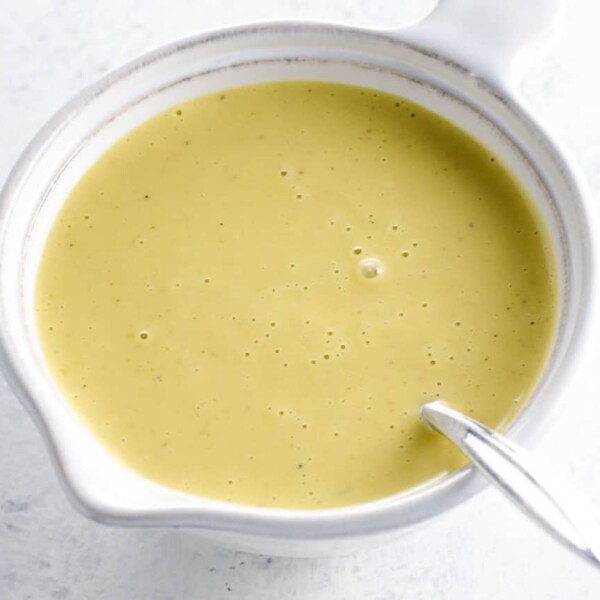 creamy lemon vinaigrette in a small white pitcher with a spoon