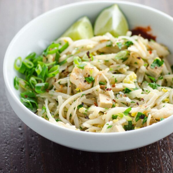 easy pad thai recipe in a bowl with chopsticks on a wooden background