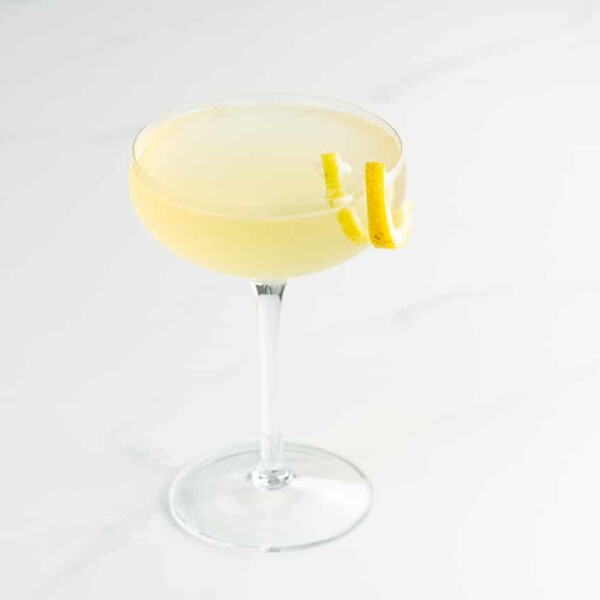 an elderflower french 75 with st germain in a coupe glass with a lemon twist