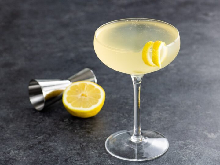 a french 76 cocktail in a coupe glass with a lemon twist