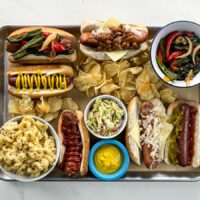hot dog bar with some ingredients and some prepared hot dogs on a tray