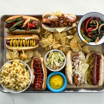 hot dog bar with some ingredients and some prepared hot dogs on a tray