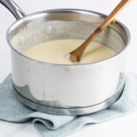 mornay sauce recipe in a pot with a wooden spoon