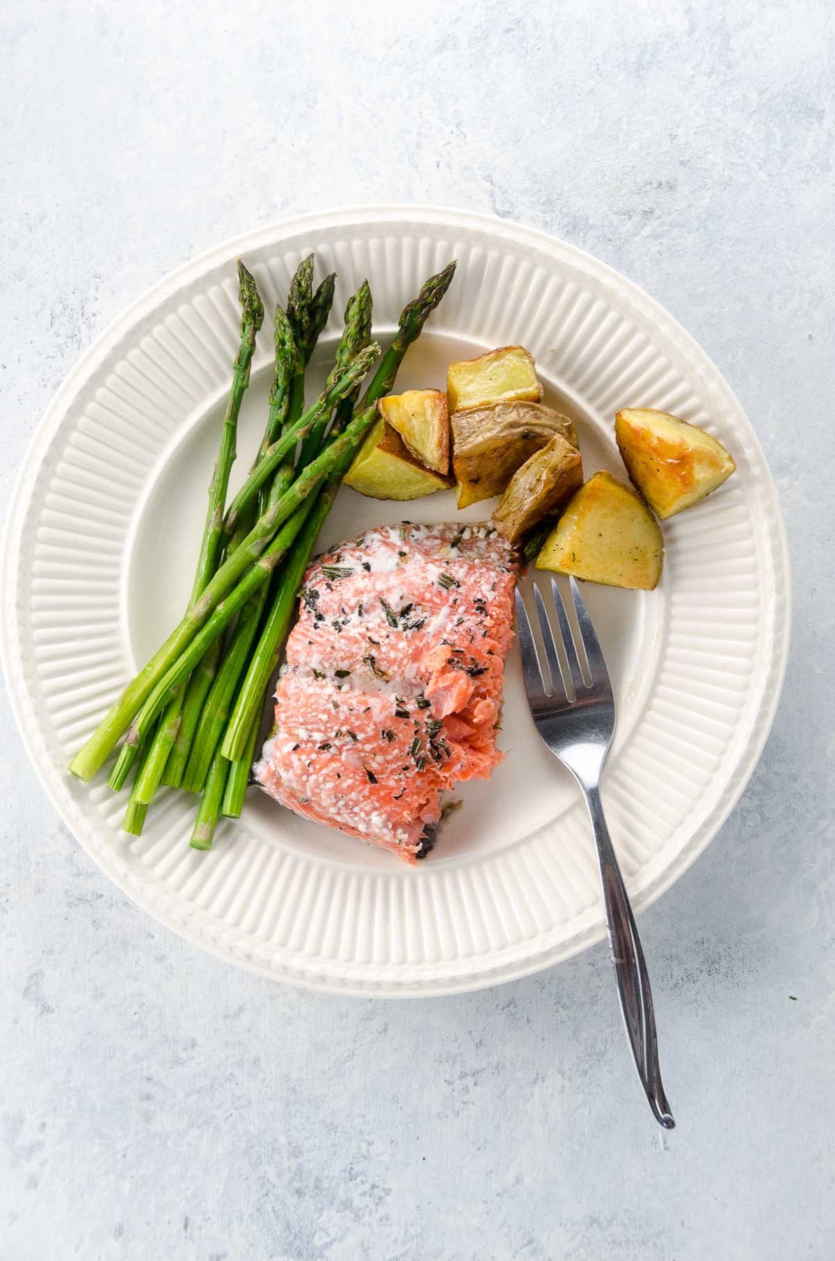 sheet pan salmon and veggies on a plate with a fork