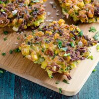 zucchini and corn fritters with a lemon wedge and sour cream
