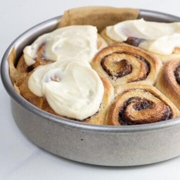 brioche cinnamon rolls with cream cheese icing in a pan