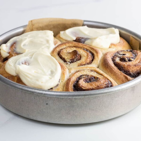 brioche cinnamon rolls with cream cheese icing in a pan