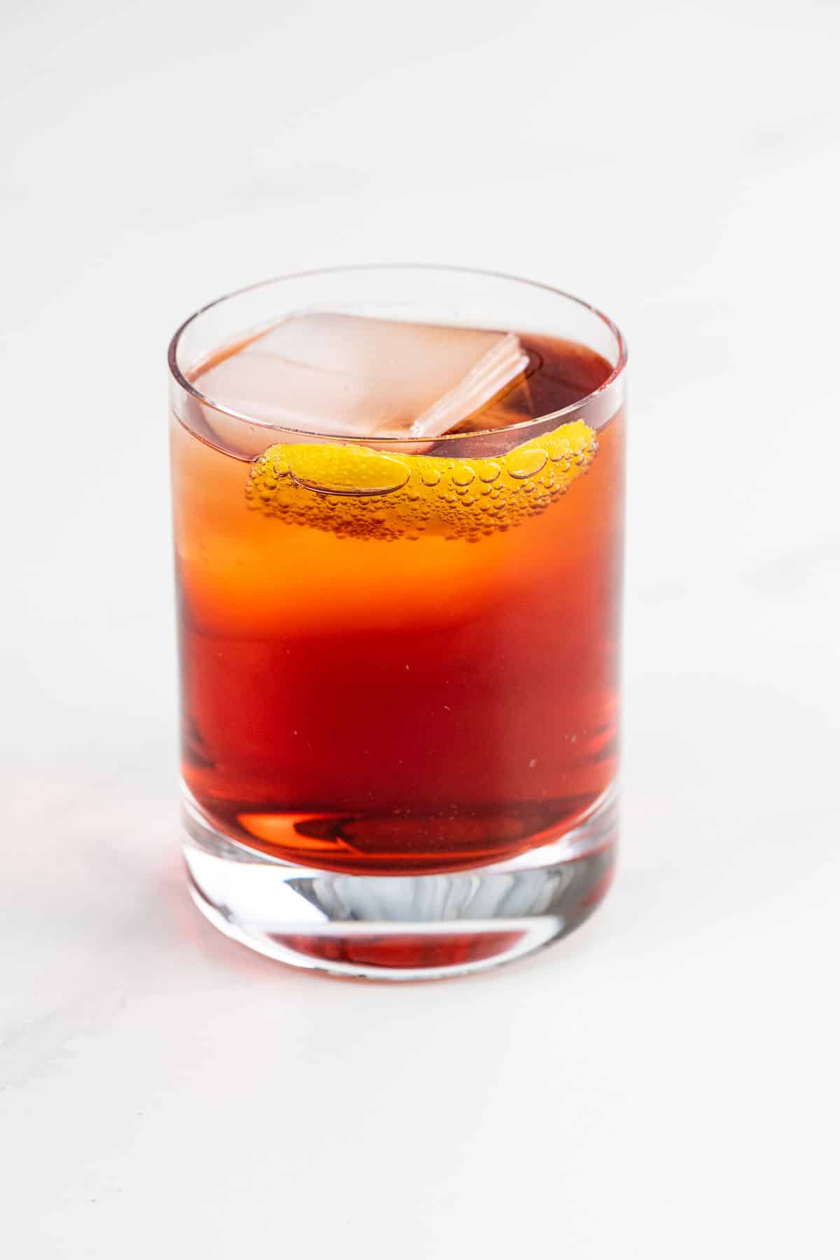 an Americano cocktail in a rocks glass garnished with an orange twist