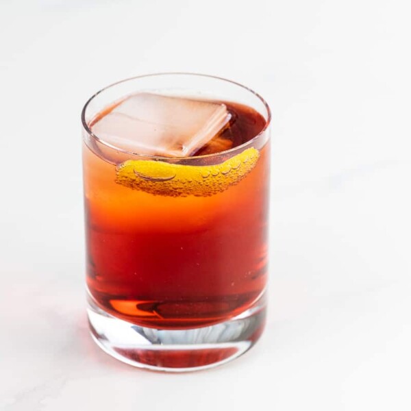 an Americano cocktail in a rocks glass garnished with an orange twist