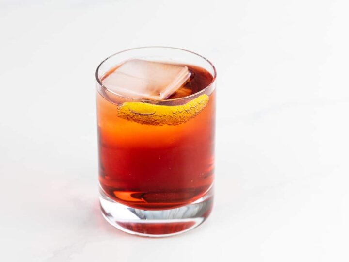 an Americano cocktail in a rocks glass garnished with an orange twist