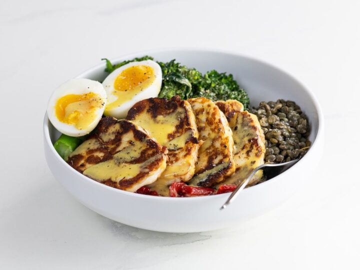 a halloumi bowl with lentils, broccolini, roasted red peppers, and a jammy egg