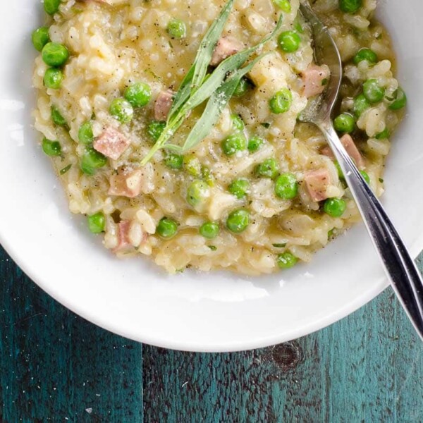 ham and pea risotto with feta and tarragon in a bowl with a spoon