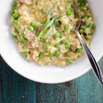 ham and pea risotto with feta and tarragon in a bowl with a spoon