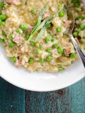 ham and pea risotto with feta and tarragon in a bowl with a spoon