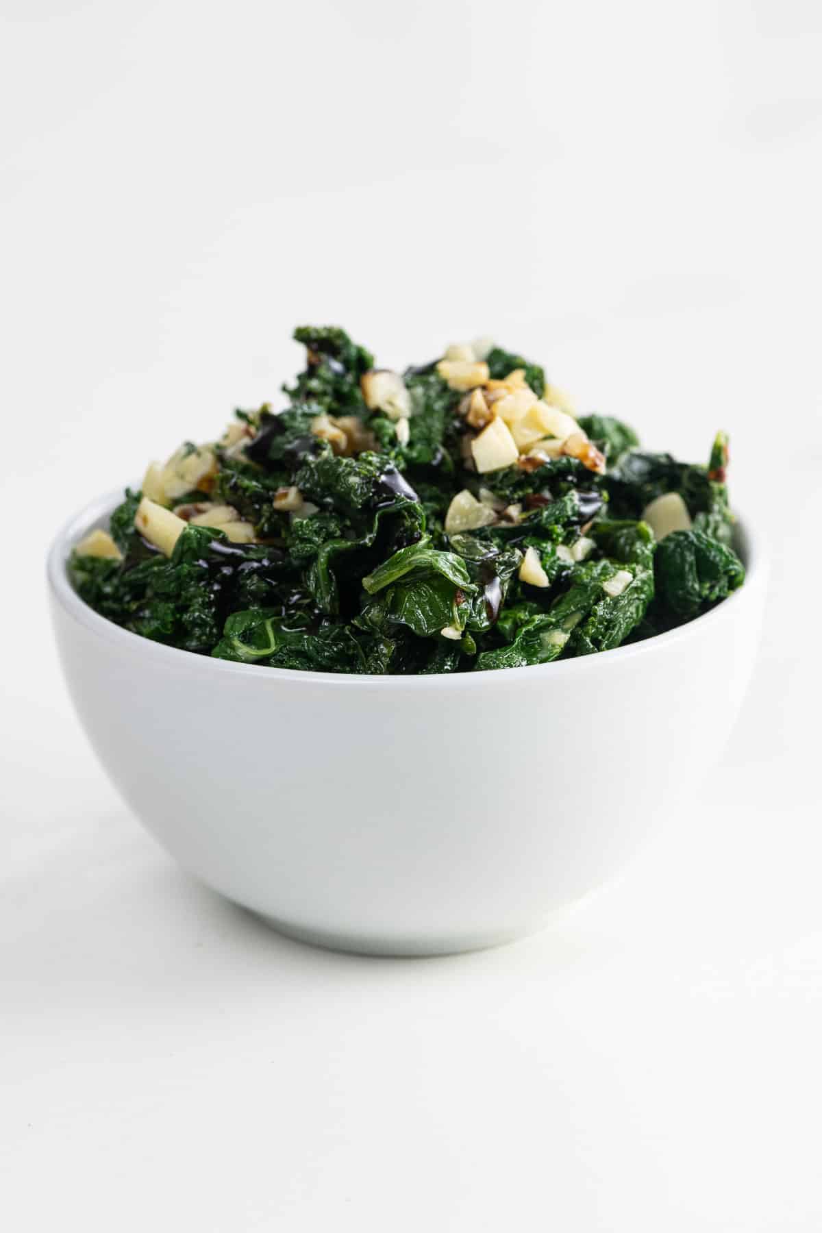 sautéed kale with garlic and parmesan in a white bowl