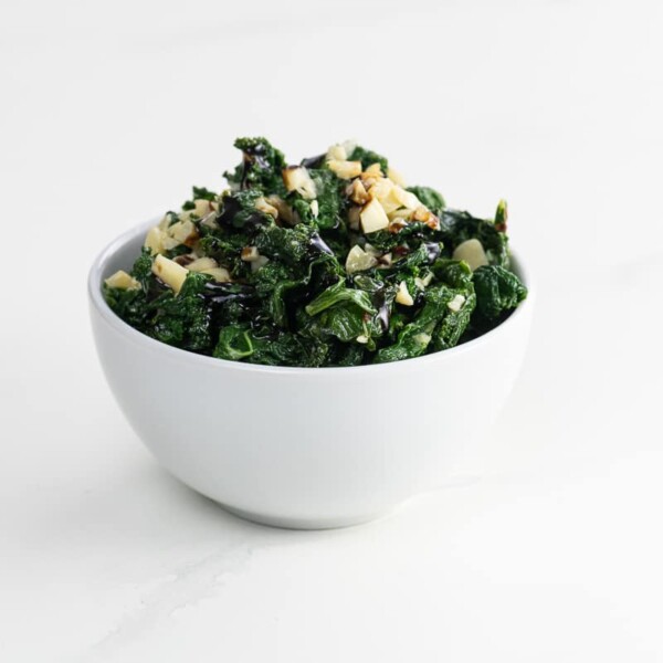 sautéed kale with garlic and parmesan in a white bowl