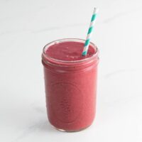 a chia smoothie in a mason jar with a paper straw